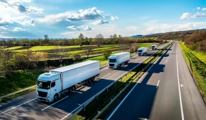 A convoy of heavy trucks hauling trailers down the highway