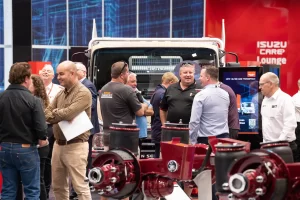 Attendees browsing displays at a truck manufacturer's stand at the truck show