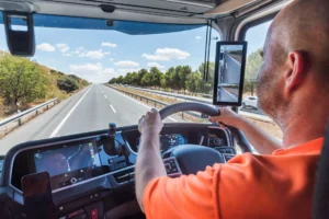 Truck driver driving on a straight highway, concentrating on driving.
